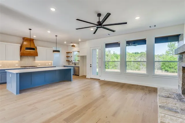 a view of kitchen with kitchen island wooden floor center island and stainless steel appliances
