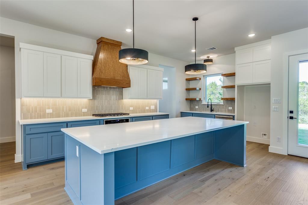505 Aermotor Loop Weatherford, TX 76085 - Photo 5 of 17 a kitchen with stainless steel appliances granite countertop a sink a stove and a wooden floors