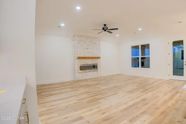 a room with kitchen island a wooden floor and a ceiling fan