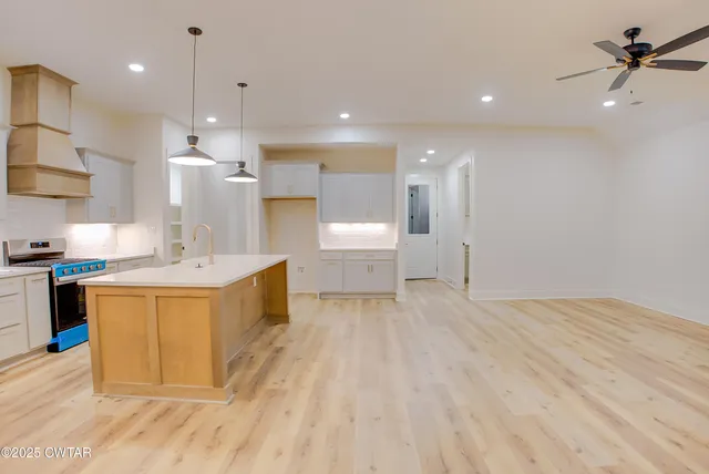 a view of a kitchen with a sink stainless steel appliances and cabinets