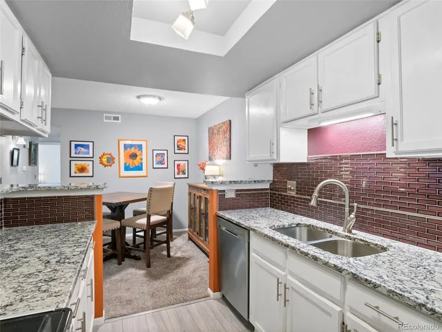 a kitchen with granite countertop a sink and a stove top oven