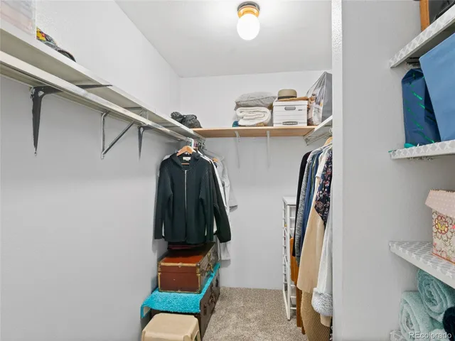 a view of walk in closet with clothes and shoes