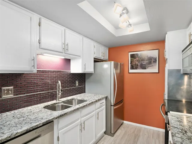 a kitchen with stainless steel appliances granite countertop a refrigerator and a sink