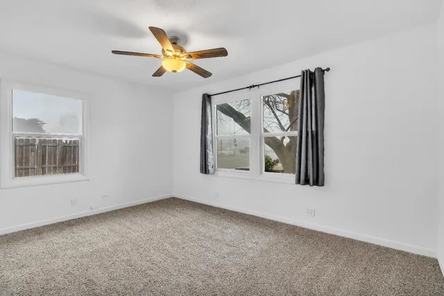 a view of a livingroom with a ceiling fan and window