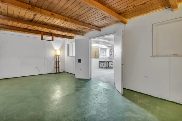 a view of a livingroom with wooden floor and a bathroom