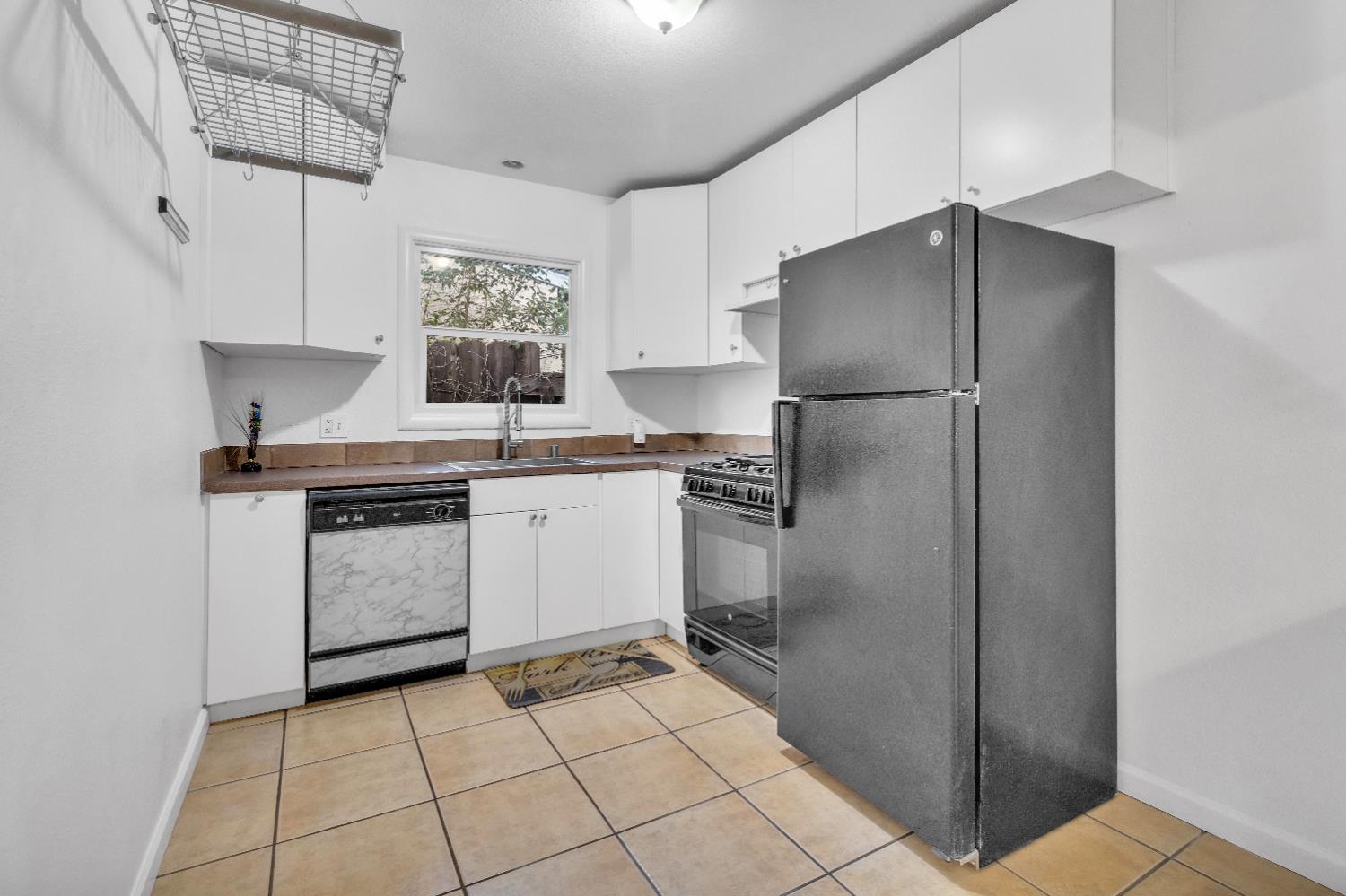 2500 Ethan Way Sacramento, CA 95821 - Photo 10 of 28 a kitchen with a stove a refrigerator and white cabinets