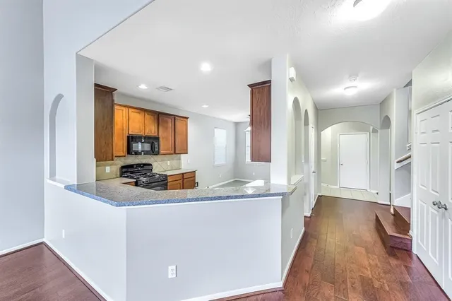 a kitchen with stainless steel appliances granite countertop a sink a stove and a refrigerator
