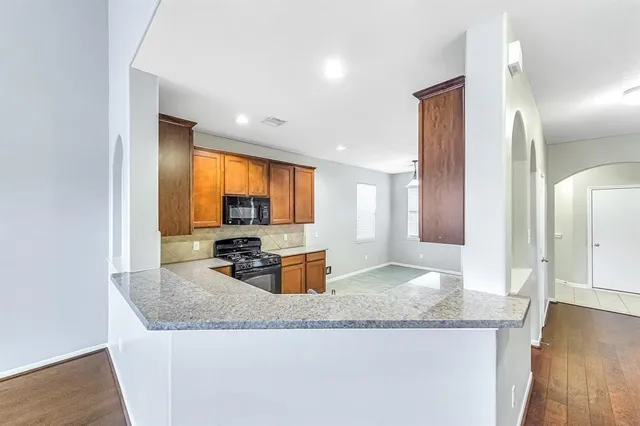 a kitchen with granite countertop a sink and a refrigerator