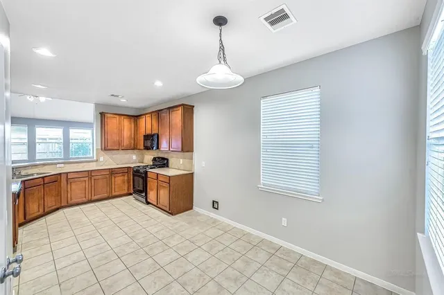 a large kitchen with a large window a sink and stainless steel appliances