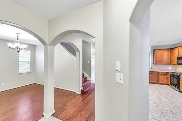 a view of a hallway with wooden floor and a living room