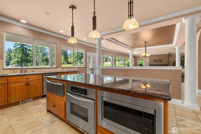 a kitchen with a stove and a view of living room
