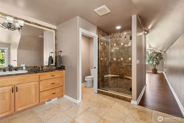 a bathroom with a granite countertop sink a mirror and shower