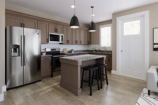 a kitchen with stainless steel appliances granite countertop a table chairs microwave and sink