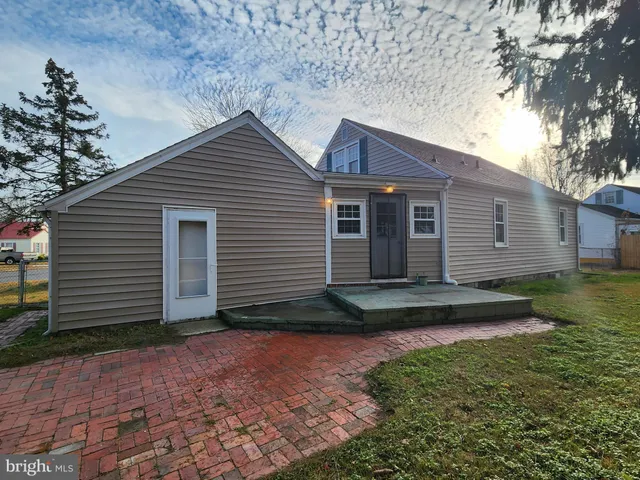 a front view of a house with a garden and trees