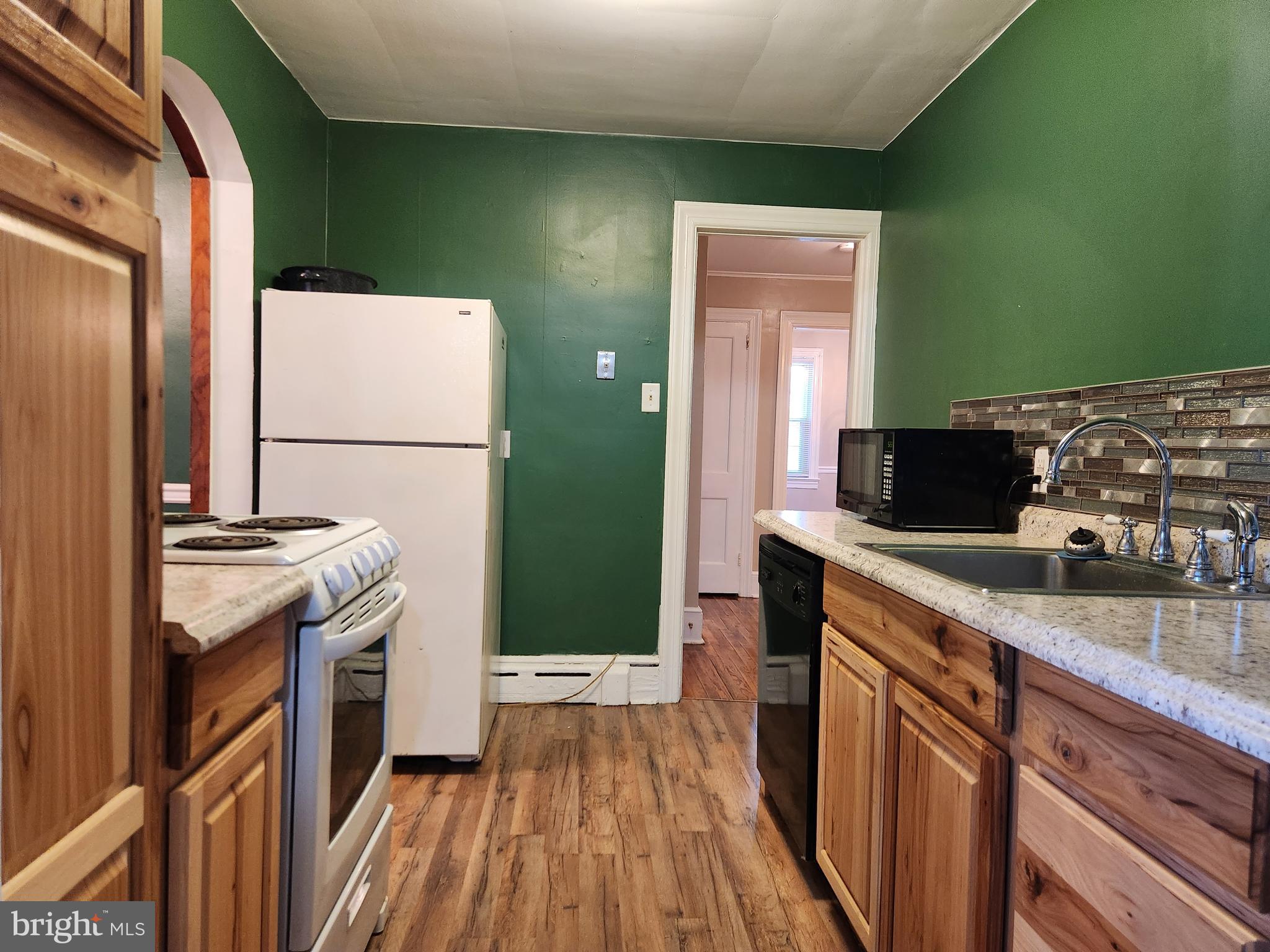 512 State Street Seaford, DE 19973 - Photo 10 of 32 a kitchen with granite countertop a sink and a stove top oven