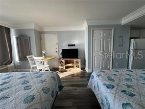 2700 North Atlantic Avenue, Unit 1003 Daytona Beach, FL 32118 - Photo 8 of 13 a bedroom with a bed and a flat screen tv