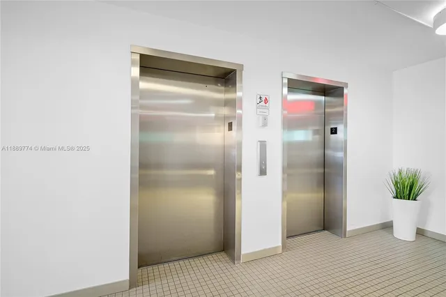 a view of an empty room with wooden floor and a glass door
