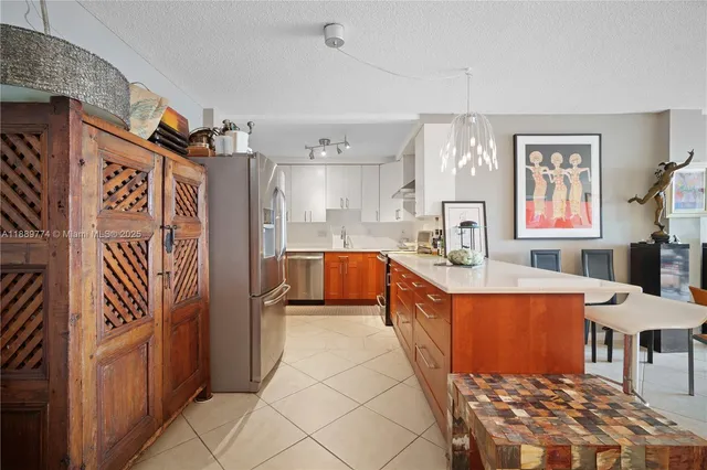 a large kitchen with stainless steel appliances granite countertop a refrigerator and a stove