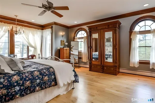 a bedroom with a large bed and windows