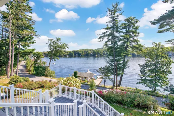 a balcony with wooden floor and lake view