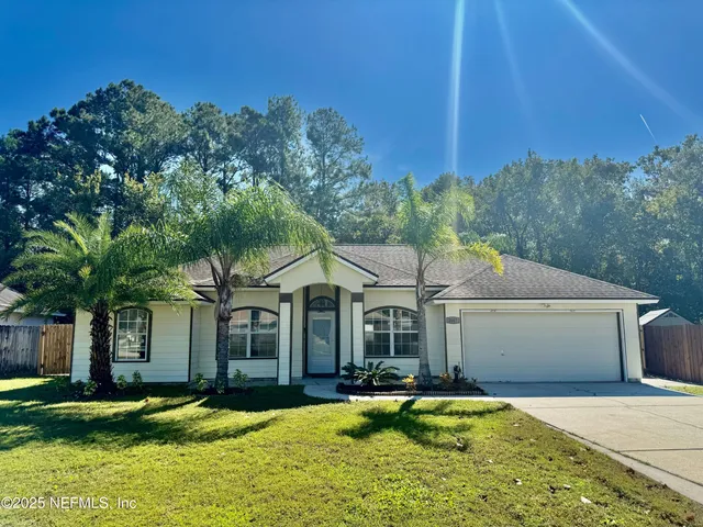 a front view of a house with a garden and yard