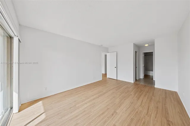 a view of a room with wooden floor and white walls