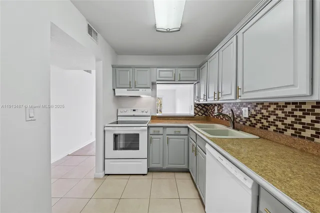 a kitchen with granite countertop white cabinets and white appliances