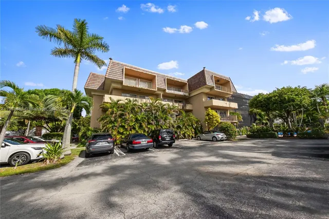 a view of a street with potted plants and palm trees