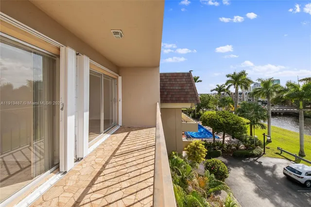 a view of a balcony with chairs and potted plants