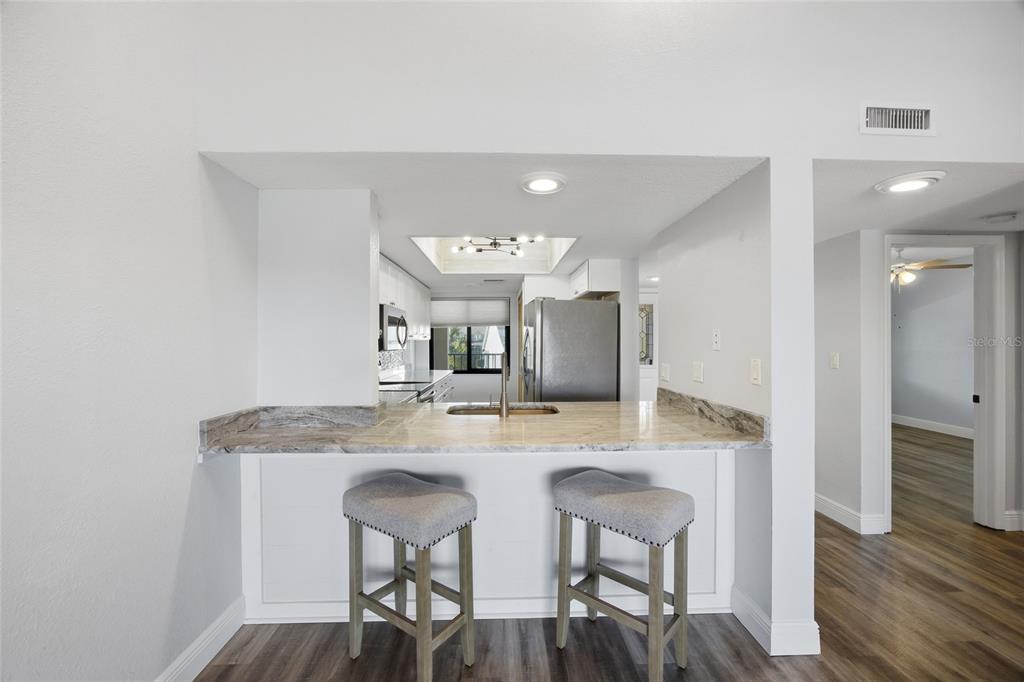 8210 Aquila Street, Unit 227 Port Richey, FL 34668 - Photo 15 of 68 a kitchen with kitchen island granite countertop a sink and a refrigerator
