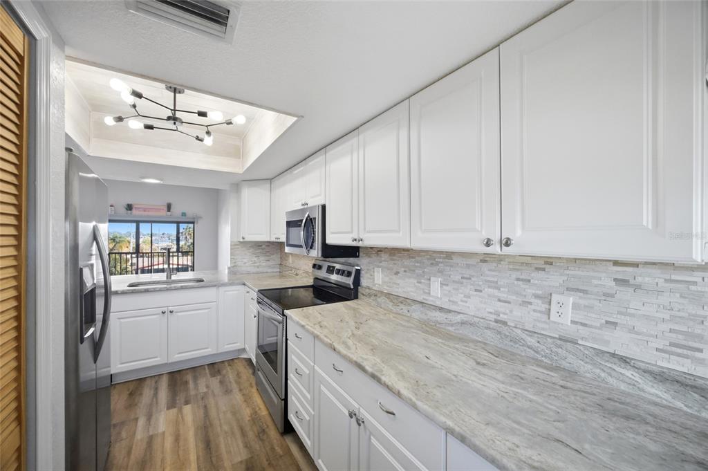 8210 Aquila Street, Unit 227 Port Richey, FL 34668 - Photo 20 of 68 a kitchen with granite countertop a sink stainless steel appliances and cabinets