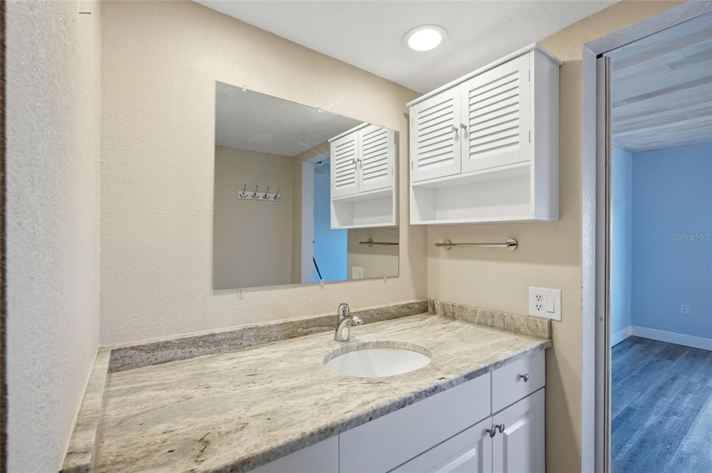 8210 Aquila Street, Unit 227 Port Richey, FL 34668 - Photo 34 of 68 a bathroom with a granite countertop sink and a mirror