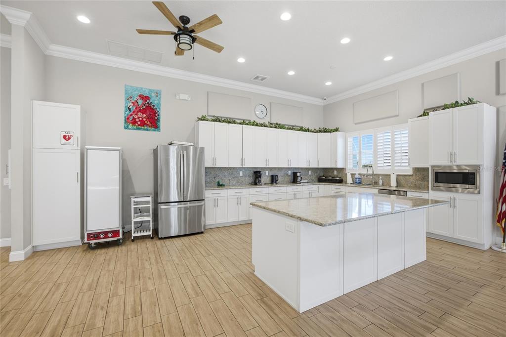 8210 Aquila Street, Unit 227 Port Richey, FL 34668 - Photo 53 of 68 a kitchen with kitchen island a white counter top space wooden floor and stainless steel appliances
