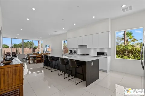 a large kitchen with kitchen island a sink a stove a center island a dining table and chairs