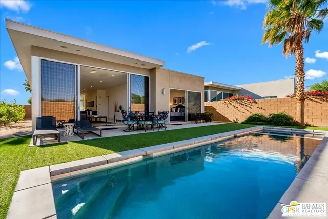a view of a house with swimming pool and sitting area
