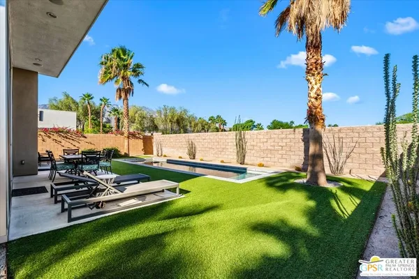 a view of swimming pool with a garden and outdoor seating