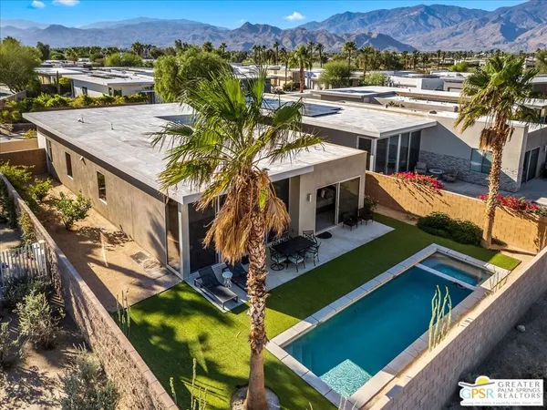 an aerial view of residential houses with yard and mountain view