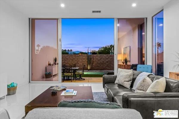 a living room with furniture and a floor to ceiling window