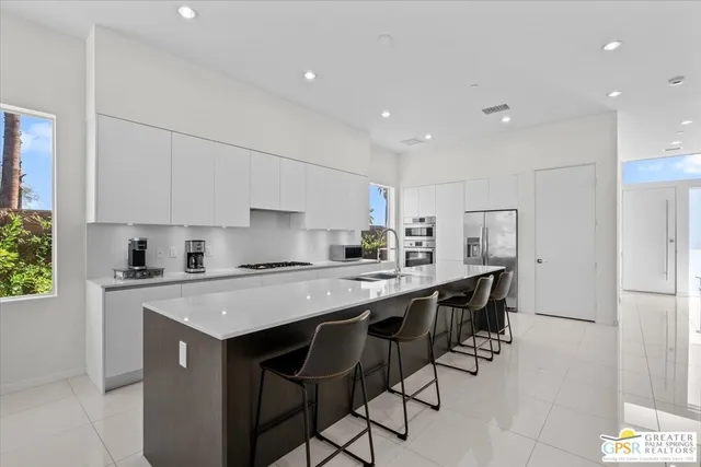 a kitchen with a sink a table and chairs in it