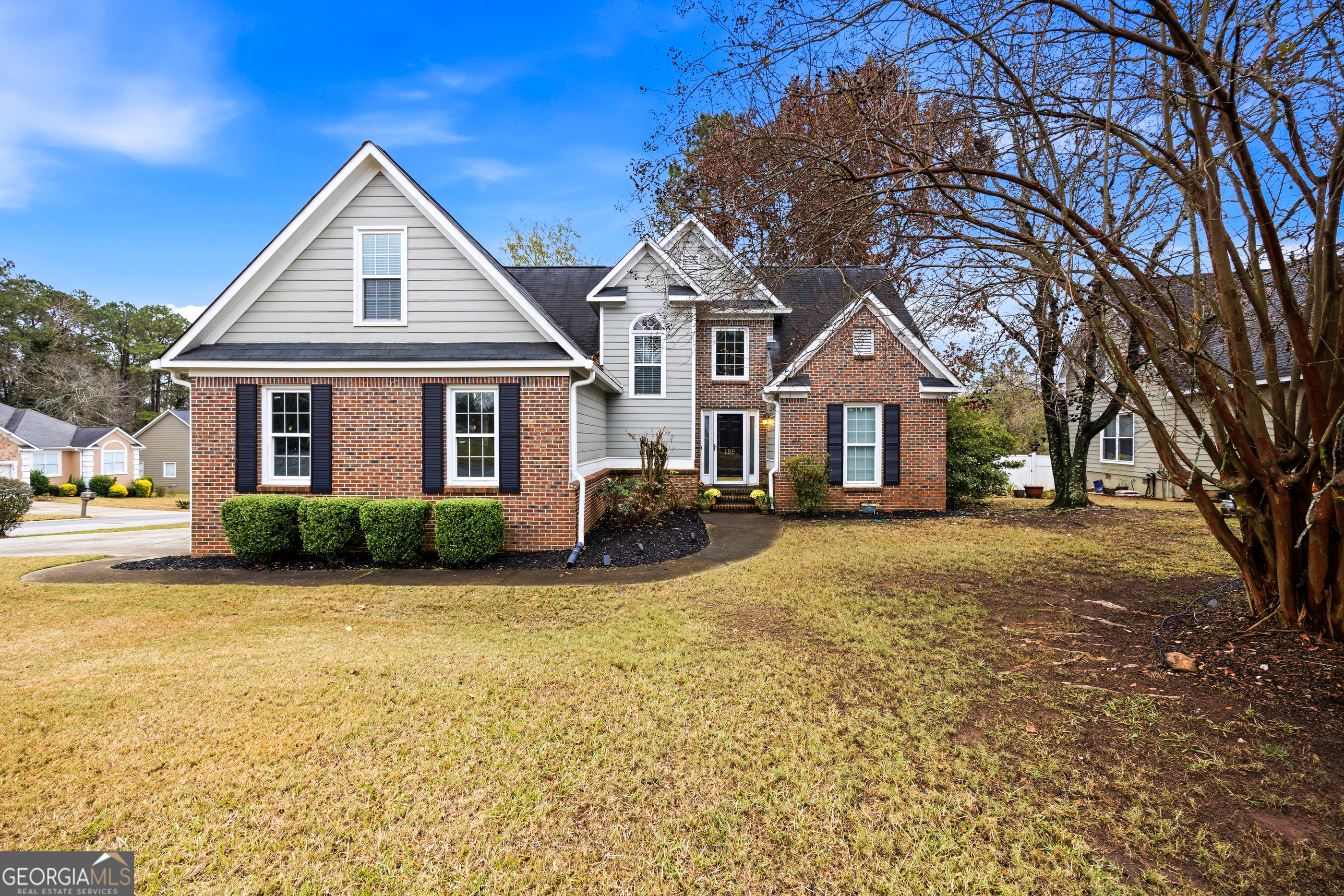 a front view of a house with yard and green space