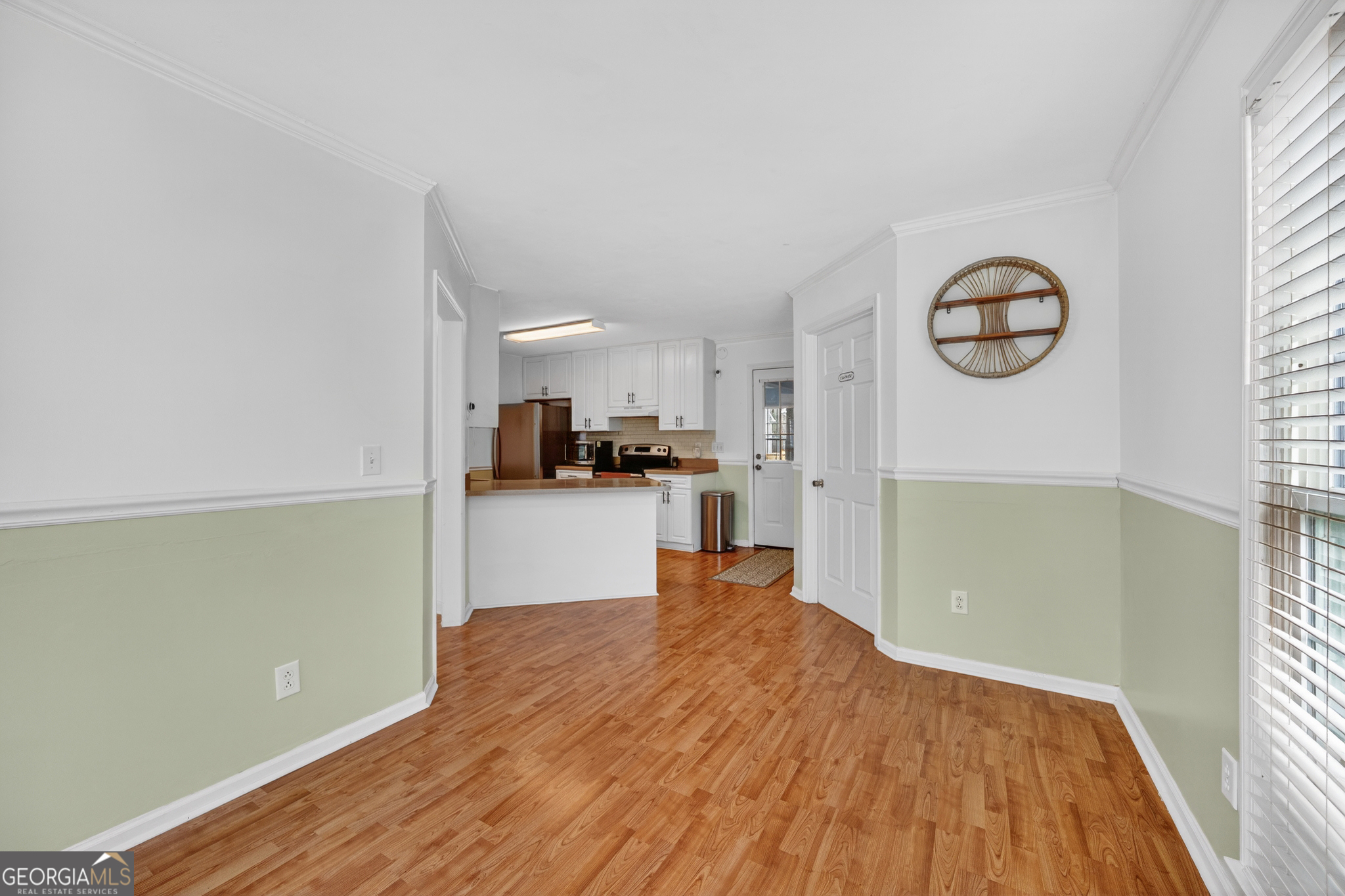 199 Springfield Boulevard Macon, GA 31210 - Photo 21 of 44 a view of kitchen and empty room with wooden floor