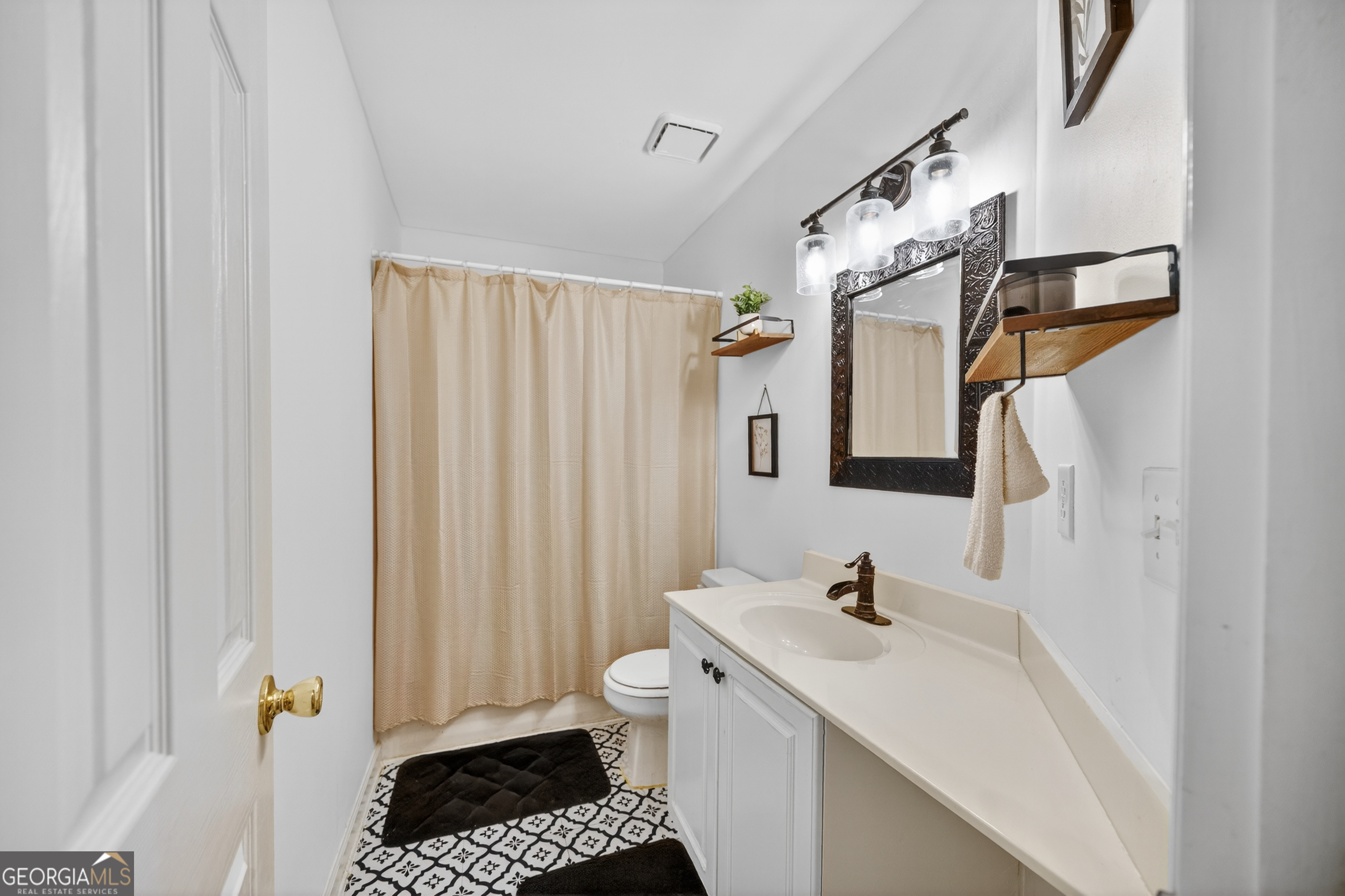 199 Springfield Boulevard Macon, GA 31210 - Photo 33 of 44 a bathroom with a sink a toilet and shower curtain