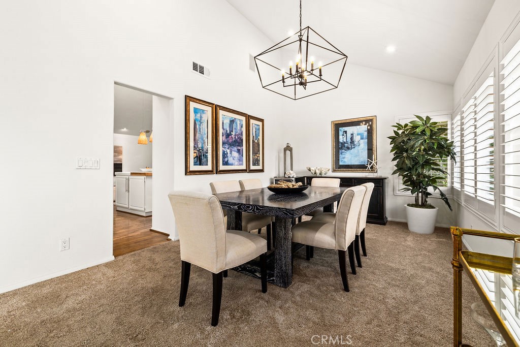 1 Centaurus, Unit 12 Irvine, CA 92603 - Photo 12 of 37 a view of a dining room with furniture a chandelier and wooden floor