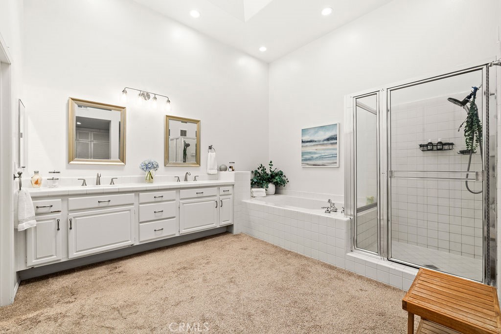 1 Centaurus, Unit 12 Irvine, CA 92603 - Photo 24 of 37 a bathroom with a double vanity sink a mirror a bathtub and shower