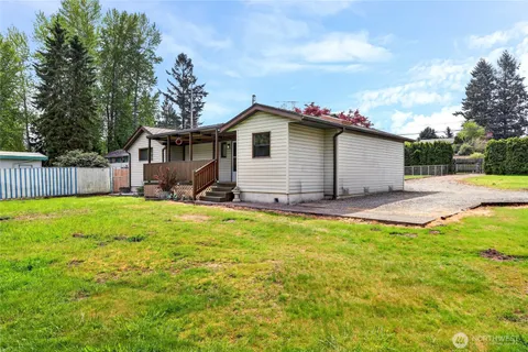 a backyard of a house with table and chairs