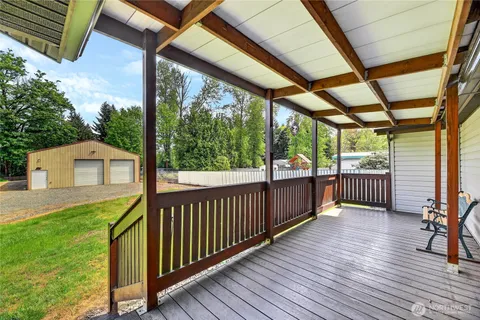 a view of a porch with wooden floor in front of house