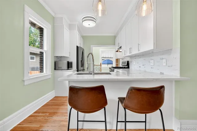 a kitchen with stainless steel appliances granite countertop a kitchen island a stove a cabinets a sink and a window