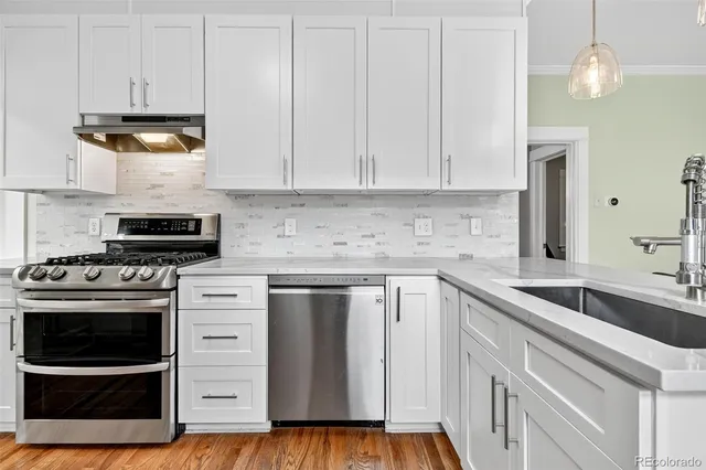 a kitchen with stainless steel appliances granite countertop a sink and a stove