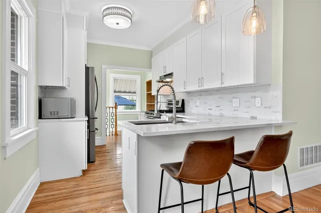 a kitchen with stainless steel appliances granite countertop a sink and a refrigerator