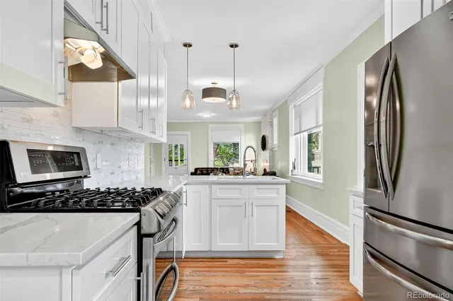 a kitchen with stainless steel appliances granite countertop a sink stove and refrigerator
